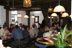 a group of people sitting at tables in a restaurant at Landgasthof am Bäumchen in Weißenfels