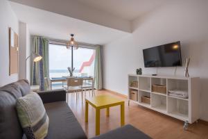 sala de estar con sofá y TV en Yellow Sun Marine I By CanariasGetaway, en Las Palmas de Gran Canaria