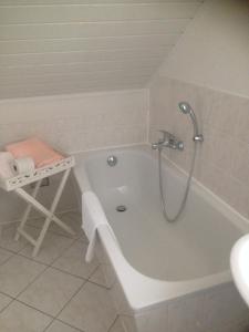 a bathroom with a bath tub with a shower at Grüne Villa in Kromlau