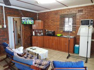 a living room with a tv and a brick wall at Cassiandra Place unit 2 in Richards Bay