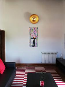 ein Wohnzimmer mit einem Sofa und einer Uhr an der Wand in der Unterkunft Quinta Dos Ribeiros in Alpalhão