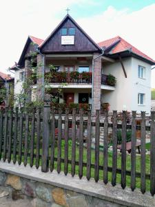 una valla de madera frente a una casa en PENSIUNEA BORDÁS PANZIÓ en Sfântu-Gheorghe