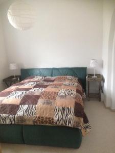 ein Schlafzimmer mit einem Bett mit einer Decke darauf in der Unterkunft Grüne Villa in Kromlau