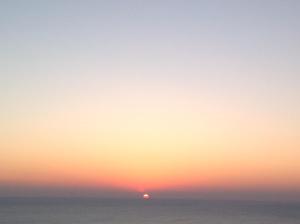 un tramonto sull'oceano con una barca in acqua di Punto di vista a Roseto degli Abruzzi
