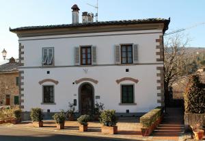 a large white building with windows on a street at Casa Al Chianti B&B in Greve in Chianti