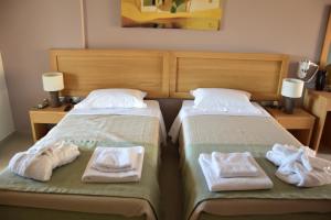zwei Betten mit Handtüchern darauf in einem Schlafzimmer in der Unterkunft Plytra Mare Hotel in Plitra