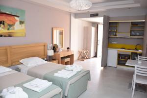 ein Hotelzimmer mit zwei Betten und einer Küche in der Unterkunft Plytra Mare Hotel in Plitra