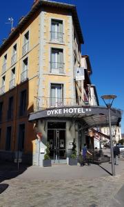 un bâtiment avec un parasol en face d'un hôtel dans l'établissement Dyke Hotel, au Puy-en-Velay