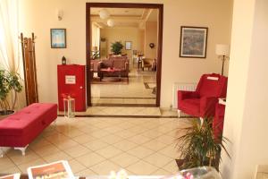 soggiorno con divani rossi di Hili Hotel a Alexandroupoli