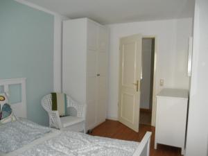 ein Schlafzimmer mit einem Bett und einem Stuhl in der Unterkunft Appartement Cécile in Potsdam