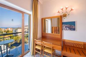 a room with a balcony with a table and a mirror at Grand Hotel Flora in Sorrento