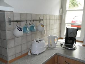 a kitchen with a counter with cups and a toaster at Appartement Cécile in Potsdam