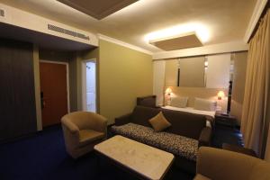 um quarto de hotel com uma cama e um sofá em Padova Hotel em Beirute