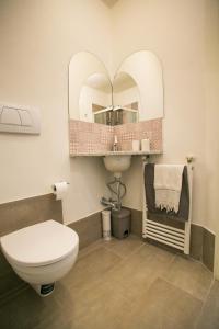 een badkamer met een toilet, een wastafel en een spiegel bij La finestra sul mare B&B in Livorno