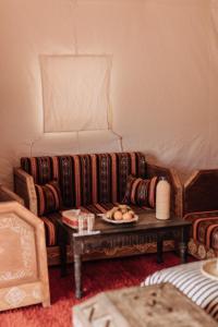 a living room with a couch and a table at Desert Luxury Camp Erg Chigaga in El Gouera