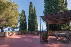 a patio with a table and chairs and trees at Villa Corinna in Ventimiglia