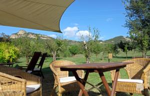 Locanda Dei Cinque Cerri في ساسو ماركوني: طاولة خشبية مع كراسي ومظلة