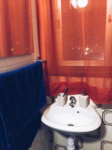 a bathroom with a white sink and a red curtain at Studio in heart of Limassol in Limassol