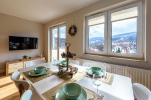 jadalnia ze stołem, krzesłami i oknami w obiekcie Apartament Widokowy - 5D Apartamenty w Świeradowie Zdroju