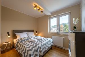 sypialnia z łóżkiem i oknem w obiekcie Apartament Widokowy - 5D Apartamenty w Świeradowie Zdroju