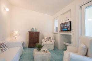 een woonkamer met twee witte banken en twee stoelen bij Sul Mare Sardegna Villa Eunice in Villasimius