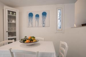 een witte eetkamer met een fruitschaal op een tafel bij Sul Mare Sardegna Villa Eunice in Villasimius