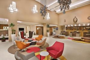 a lobby with chairs and tables and a library at Park Mall Hotel & Conference Center in Sétif