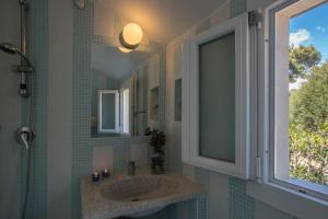 een badkamer met een wastafel en een raam bij Sul Mare Sardegna Villa Eunice in Villasimius +16 foto's