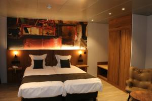 ein Schlafzimmer mit einem großen Bett und einem Gemälde an der Wand in der Unterkunft Hotel Botteltje in Ostende