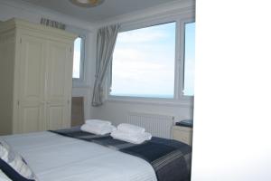 a bedroom with a bed with two towels on it at Rivendell Guest House in St Ives