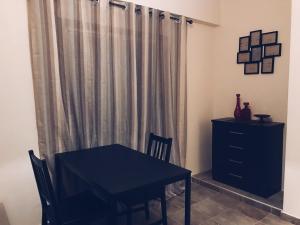 a dining room with a black table and a curtain at Studio in heart of Limassol in Limassol