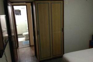 a bedroom with a door leading to a bathroom with a toilet at Costeira Praia in Natal
