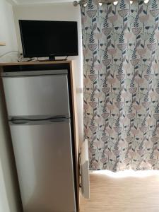 a television on top of a refrigerator in a room at Altamira Camping in Queveda