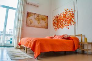 een slaapkamer met een bed met een oranje deken bij B&B Tecla in Napels