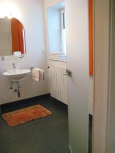 ein Badezimmer mit einem Waschbecken, einem Spiegel und einem Waschbecken in der Unterkunft Ferienwohnung Kathrein in Reutte