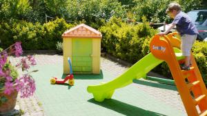 a young boy playing on a slide in a playground at Albergo Ristorante Sterlina in Grizzana