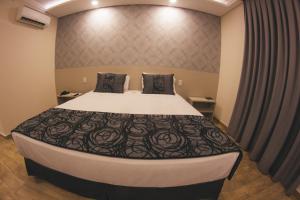 Cama ou camas em um quarto em Summit Suítes Hotel Caçapava