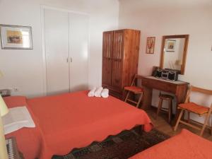 a bedroom with a red bed and a wooden cabinet at Dafni Apartments in Kastri