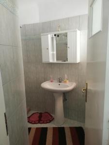 a bathroom with a sink and a mirror at Dafni Apartments in Kastri