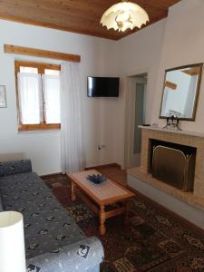 a living room with a couch and a fireplace at Dafni Apartments in Kastri