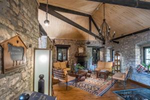 a living room filled with furniture and a stone wall at Princess Lanassa in Kostitsi