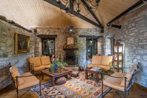 a living room filled with furniture and a stone wall at Princess Lanassa in Kostitsi