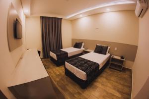 Cama ou camas em um quarto em Summit Suítes Hotel Caçapava