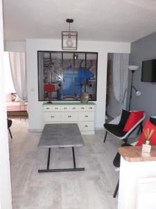 een woonkamer met een dressoir en een tafel bij La Pergola de la Plage in Gruissan