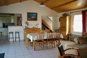 una cucina e una sala da pranzo con tavolo e sedie di Maison idéale pour des vacances au cœur de l’Ile de Noirmoutier a La Guérinière