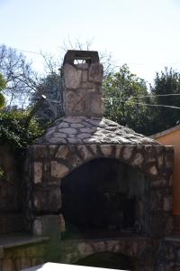 a large stone fireplace in a yard at Apartments Ivka in Malinska