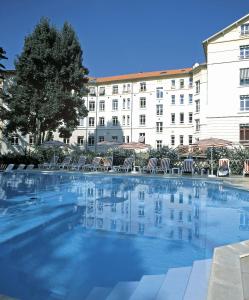 a large swimming pool in front of a building at Logis Les Loges du Parc in La Roche-Posay