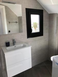 een badkamer met een witte wastafel en een spiegel bij Apartamentos Kronox in Nerja
