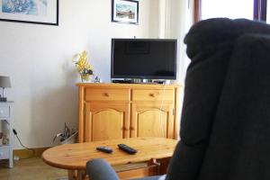 a person sitting in a chair in front of a television at Belle maison à 600 mètres de la grande plage de Saint-Gilles-Croix-de-Vie in Saint-Gilles-Croix-de-Vie