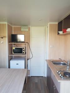 a small kitchen with a microwave and a sink at Altamira Camping Park in Queveda